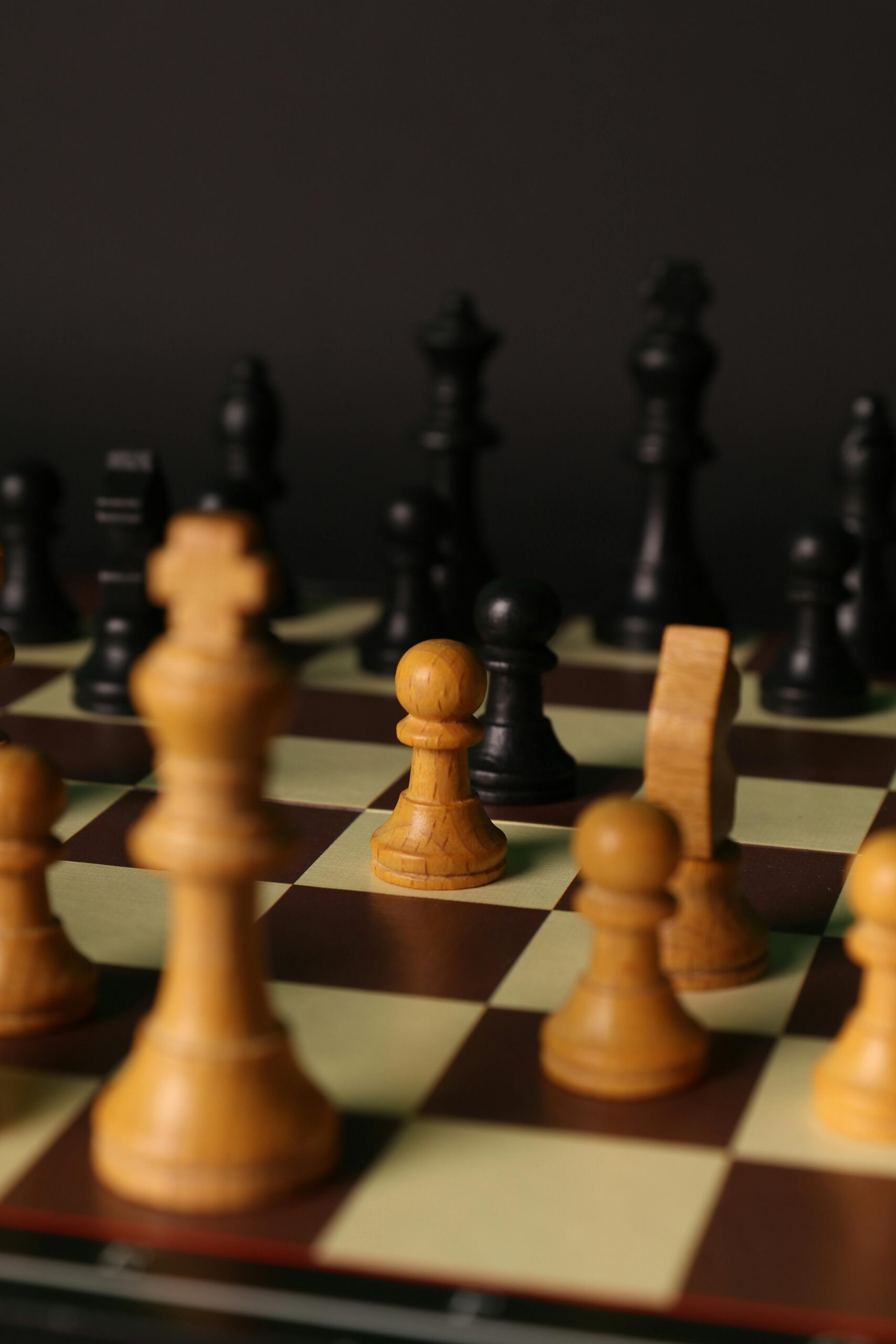 Detailed view of wooden chess pieces on a checkered board, highlighting game strategy.